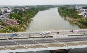 Vista aérea del río Grijalva a su paso por Villahermosa, con el puente en primer plano y niveles bajos de agua durante el periodo de estiaje.