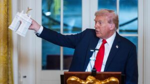 Donald Trump sostiene una maqueta del arco que planea construir entre el Monumento a Lincoln y el Cementerio de Arlington