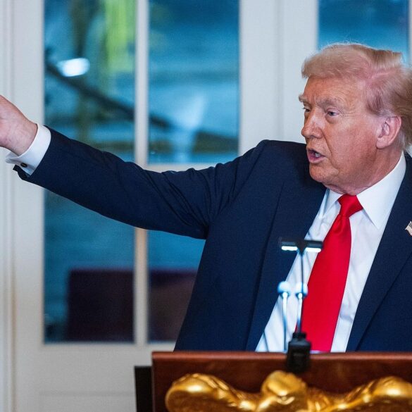 Donald Trump sostiene una maqueta del arco que planea construir entre el Monumento a Lincoln y el Cementerio de Arlington