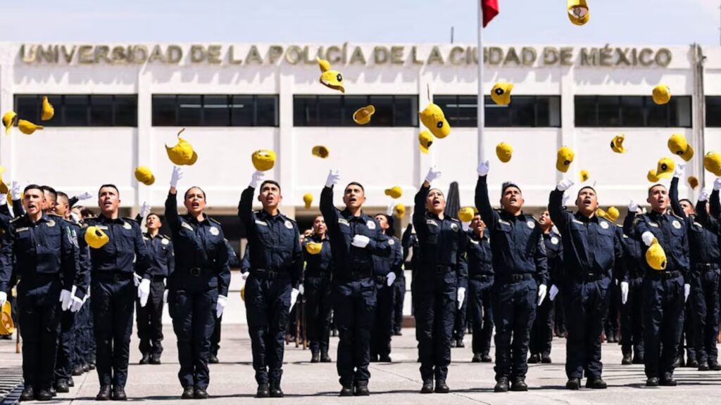 Egresados de la Universidad de la Policía de Ciudad de México lanzan sus birretes durante una ceremonia
