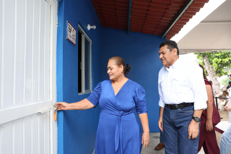 Beneficiaria abre la puerta de una nueva vivienda rural entregada en Tabasco