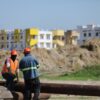 Trabajadores de la construcción frente a viviendas de un desarrollo habitacional en Tabasco