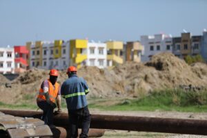 Trabajadores de la construcción frente a viviendas de un desarrollo habitacional en Tabasco