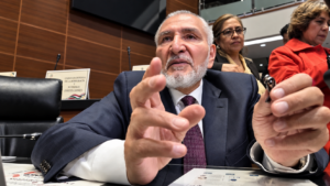 El senador Adán Augusto López gesticula con ambas manos mientras responde a la prensa en su escaño del Senado