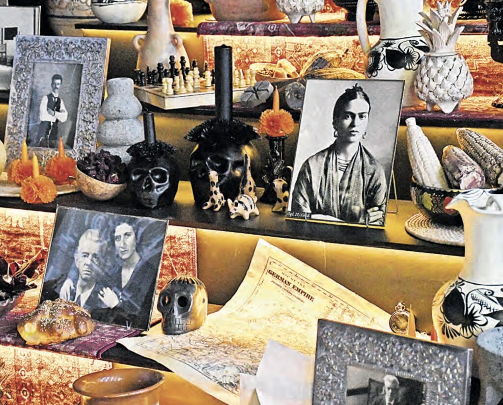 Detalle de la ofrenda a Guillermo Kahlo con fotografías familiares, un tablero de ajedrez, calaveras, flores de cempasúchil y mazorcas.