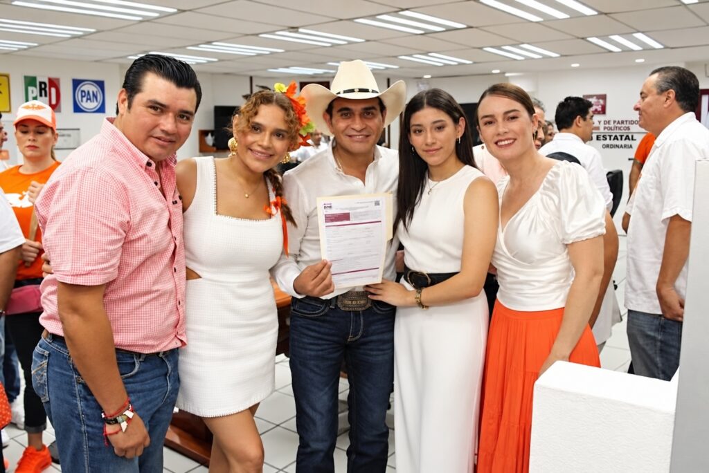 Armín Marín Saury, con sombrero blanco y documentación electoral, acompañado de familiares durante su registro como candidato.