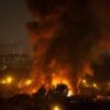 Incendio de grandes dimensiones ilumina la noche en una ciudad de Ucrania, con una enorme columna de humo junto a edificios residenciales.