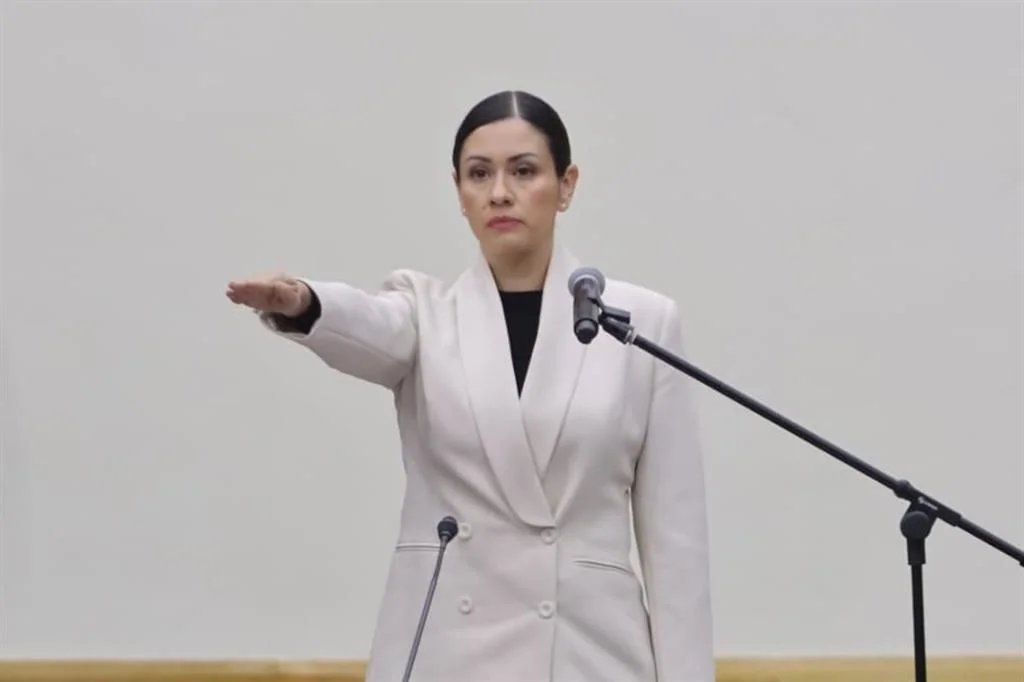 Blanca Yassahara Cruz García rinde protesta como presidenta provisional del Instituto Nacional Electoral, con el brazo derecho extendido, durante la sesión del Consejo General.
