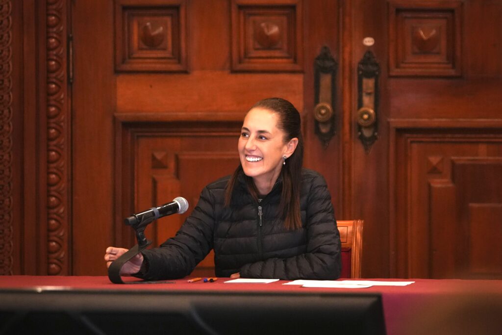Claudia Sheinbaum durante una reunión de trabajo en Palacio Nacional, sentada frente a un micrófono para evaluar programas de gobierno.
