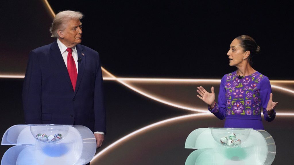 Donald Trump observa a Claudia Sheinbaum mientras la presidenta mexicana habla y gesticula durante un acto conjunto ante atriles.