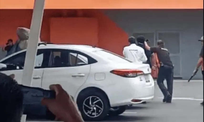Personal de seguridad interviene junto a un automóvil blanco durante la retención de un hombre señalado por presunto robo en una plaza comercial de Carrizal.
