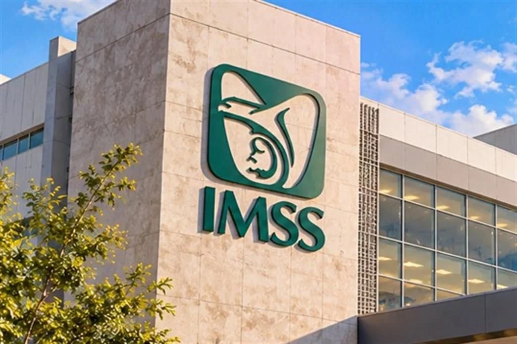 Muro claro con el logotipo verde del IMSS frente a un cielo azul despejado