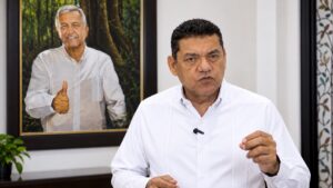 Javier May Rodríguez emite un mensaje por los 15 años de Morena, frente a un retrato de Andrés Manuel López Obrador.