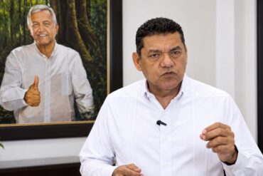 Javier May Rodríguez emite un mensaje por los 15 años de Morena, frente a un retrato de Andrés Manuel López Obrador.