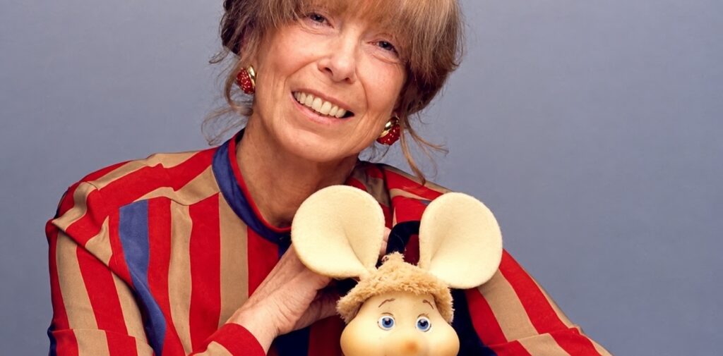 Maria Perego sonríe mientras sostiene al entrañable personaje infantil Topo Gigio.