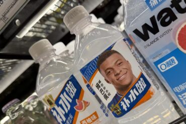 Botellas de bebidas deportivas chinas con la imagen de Kylian Mbappé en sus etiquetas durante la controversia comercial con China.