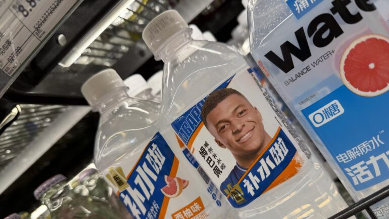 Botellas de bebidas deportivas chinas con la imagen de Kylian Mbappé en sus etiquetas durante la controversia comercial con China.