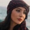 Retrato de Najmeh Amini, estudiante iraní de 23 años condenada a muerte por blasfemia en redes sociales, con pañuelo oscuro y el mar al fondo