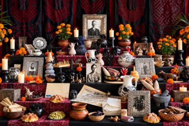 Ofrenda de Día de Muertos dedicada a Guillermo Kahlo en la Casa Azul, con retratos familiares, flores de cempasúchil, veladoras y objetos personales.