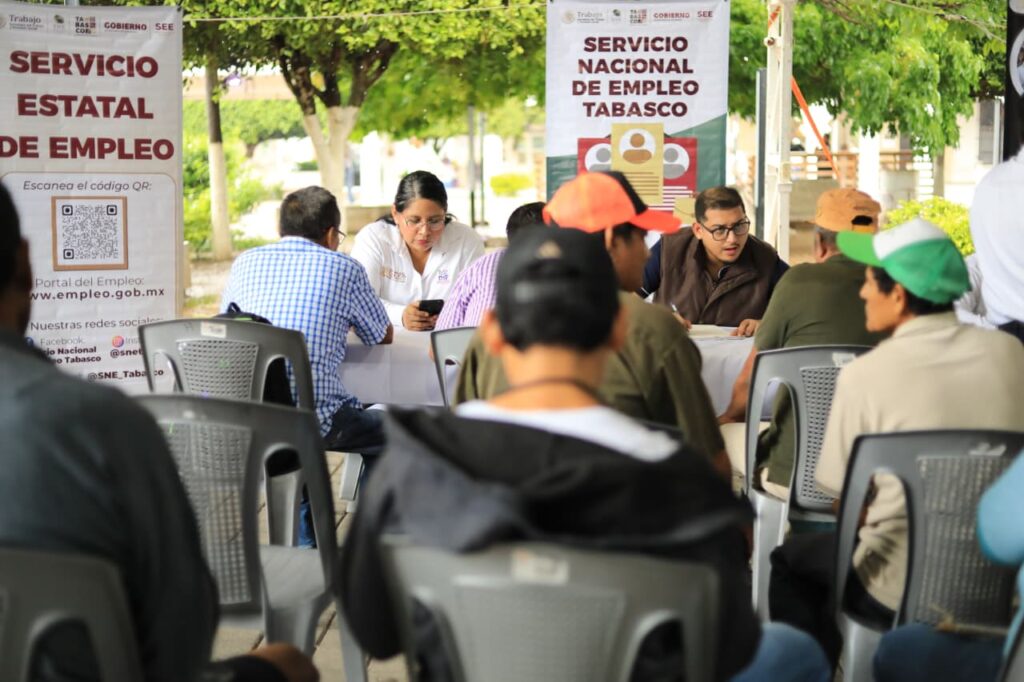 Hombre sonriente sentado ante documentos de solicitud laboral durante la Feria Nacional de Empleo en Comalcalco.