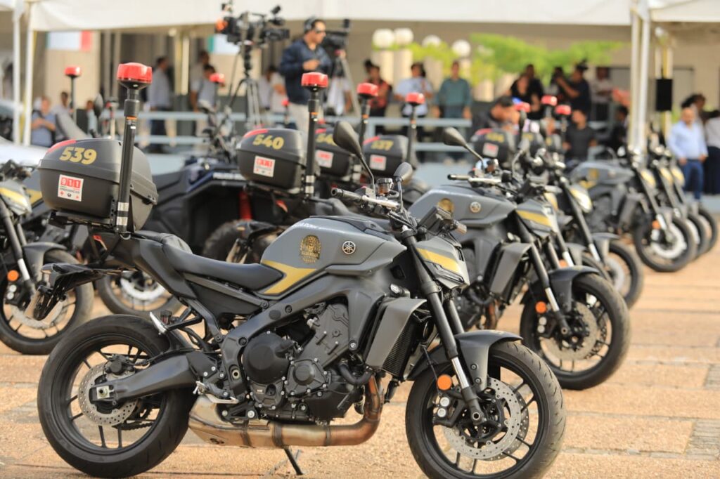 Motocicletas policiales negras equipadas con luces de emergencia, estacionadas durante la presentación de unidades de seguridad.