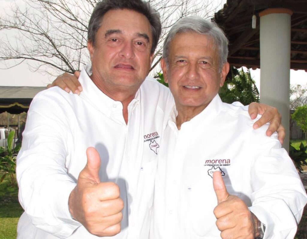 Pío López Obrador y Andrés Manuel López Obrador, abrazados y con el pulgar arriba, con camisas blancas de Morena Chiapas