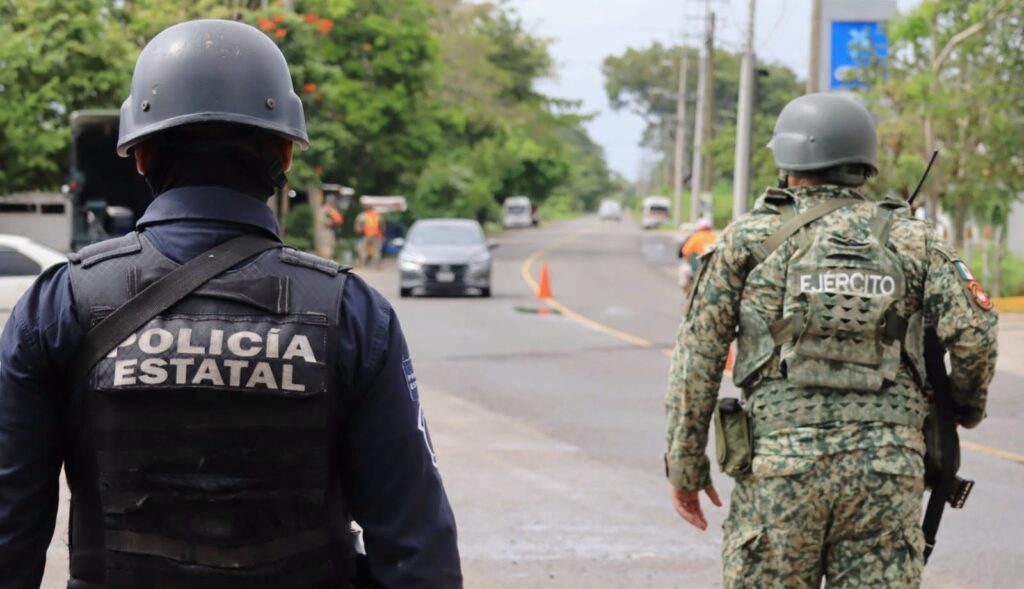 Un policía estatal y un militar del Ejército de espaldas en un punto de revisión vehicular en Tabasco
