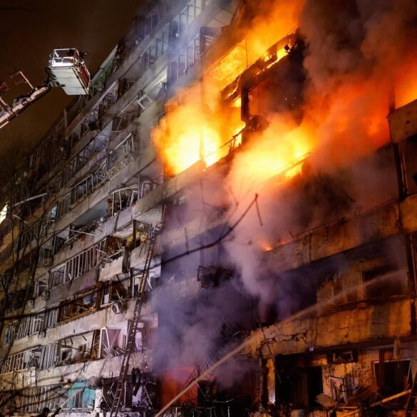 Edificio envuelto en llamas durante un incendio de gran magnitud, mientras bomberos utilizan una plataforma elevada para combatir el fuego.