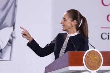 Claudia Sheinbaum sonríe y señala con el dedo desde el podio de la conferencia matutina al hablar de la Modalidad 40 del IMSS