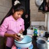Niña prepara alimentos en una cocina doméstica, imagen ilustrativa de las tareas del hogar que aborda el reportaje sobre trabajo infantil en Tabasco.
