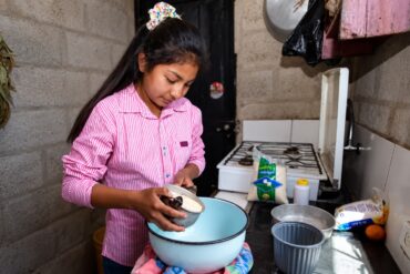 Niña prepara alimentos en una cocina doméstica, imagen ilustrativa de las tareas del hogar que aborda el reportaje sobre trabajo infantil en Tabasco.