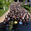 Multitud de corredores con sombreros y paliacates avanza junto a una banda con uniformes amarillos en la VaqueRun Tabasco 2026