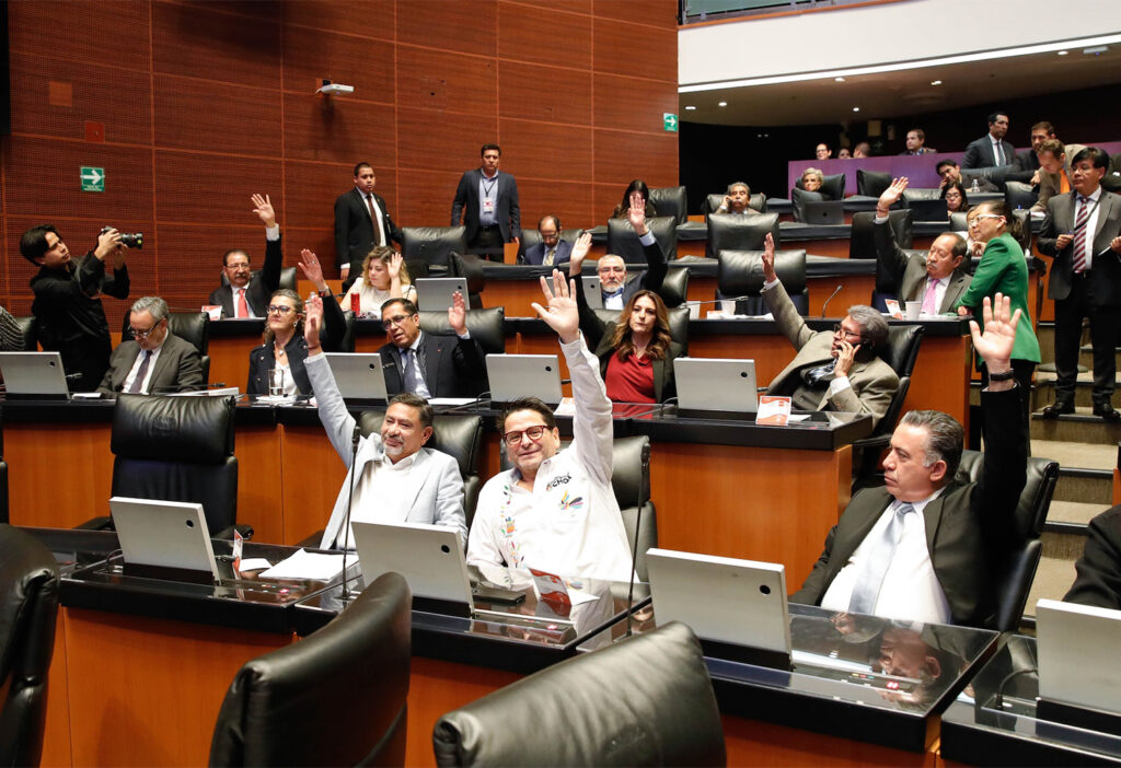Senadores mexicanos levantan la mano durante una votación en el pleno del Senado de la República.
